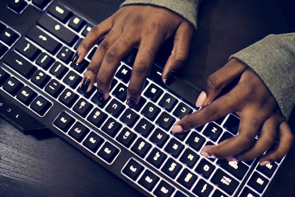 Closeup of hands working on computer keyboard