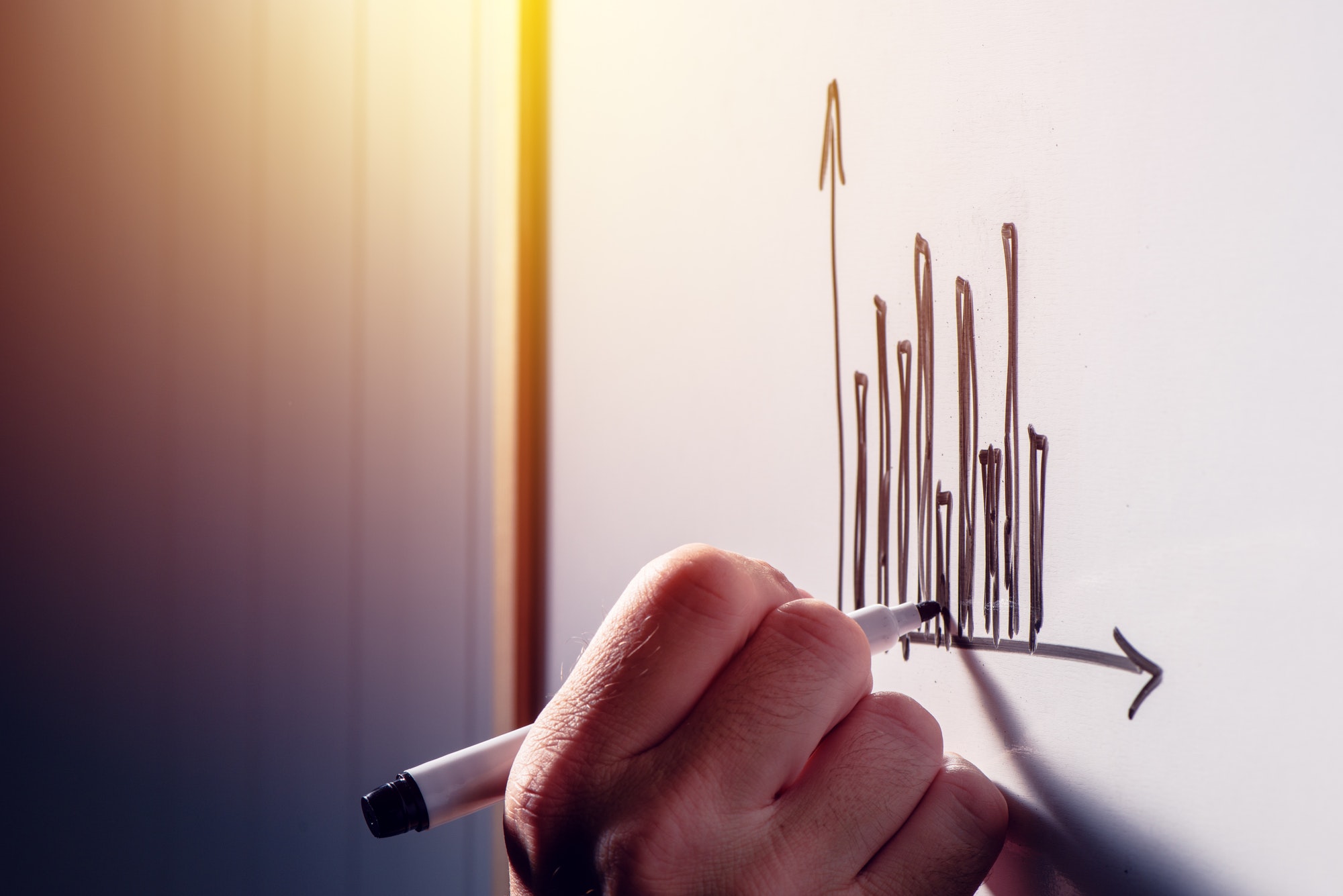 Businessman drawing a graph chart on whiteboard