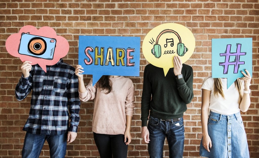 Friends holding up thought bubbles with social media concept ico